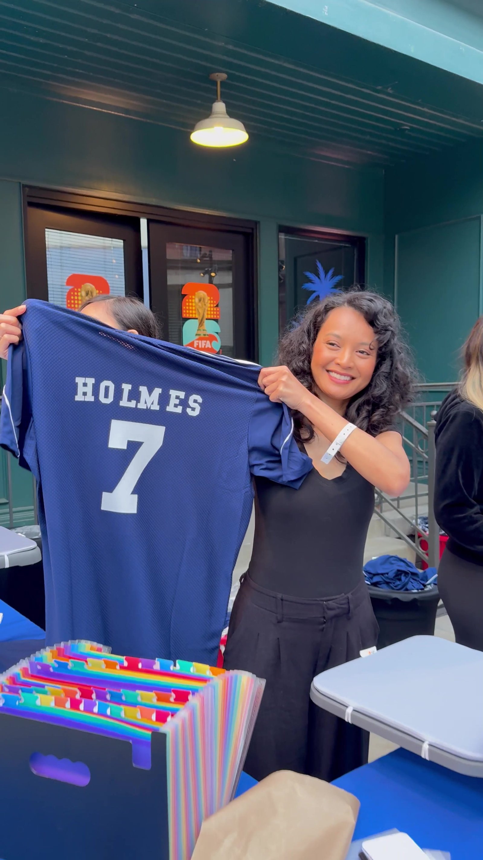 Guest proudly holding up a navy jersey personalized with her name and number
