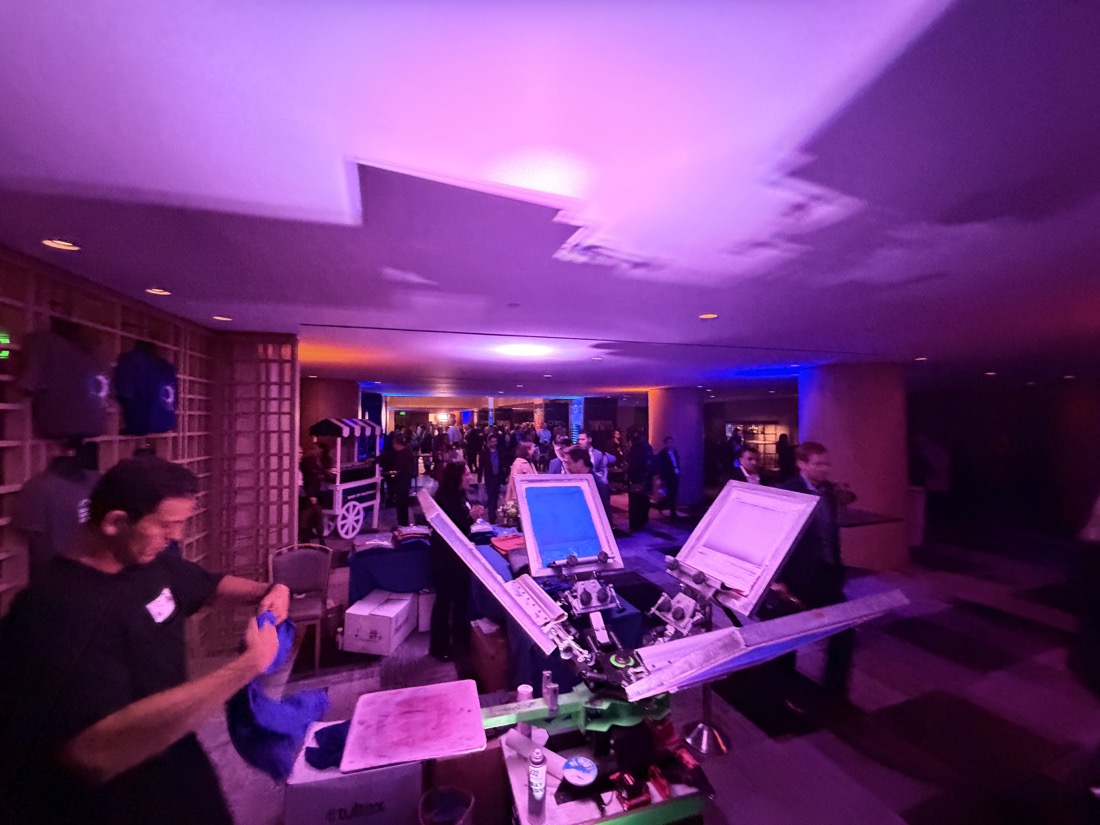 Evening company party with a personalization station glowing at the edge of the room
